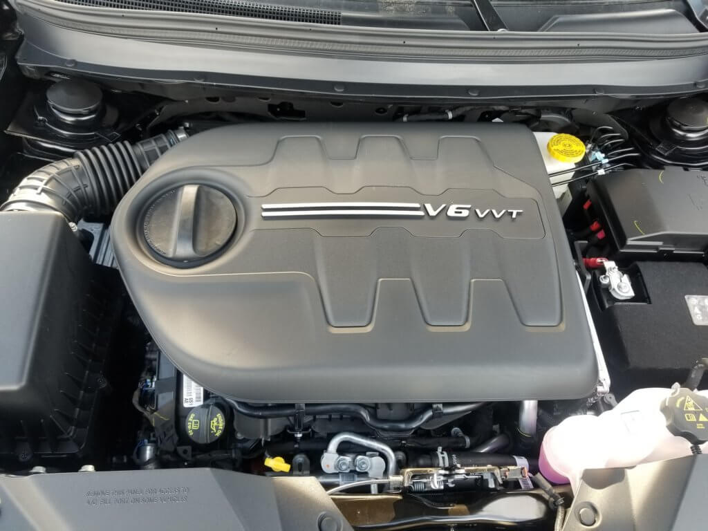 Jeep Cherokee 3.2L engine bay with the engine oil fill cap, dip stick, and engine oil filter access panel pictured