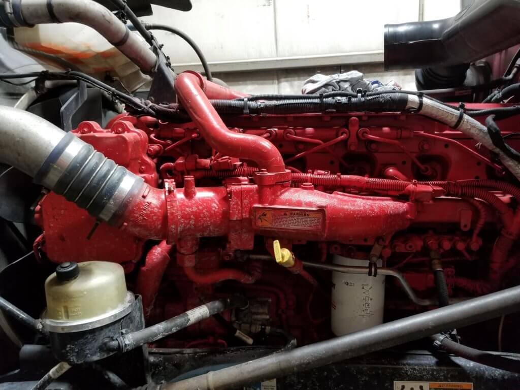 Cummins ISX crankcase filter mounted behind the cold side charge pipe